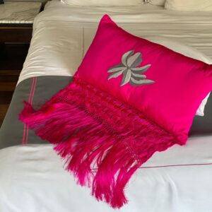 Cojín fucsia con flecos artesanales